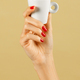 Unrecognizable woman holding coffee cup in hand against brown backdrop - PhotoDune Item for Sale