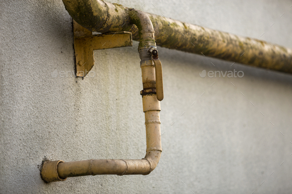 Close-up detail of old dirty painted yellow natural gas pipes with welding seams