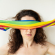 A girl covers her eyes with a bright multi-colored rainbow LGBT flag. LGBT girl. There is no support - PhotoDune Item for Sale