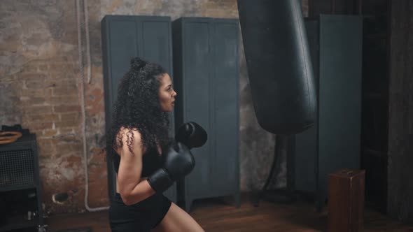 Strong African American Woman Practices Boxing in Gym alt