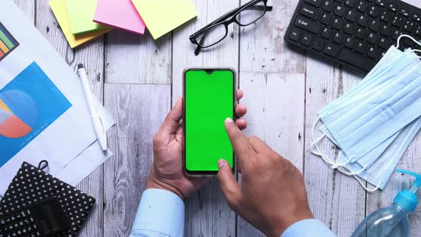 Top View of Man Hand Using Smart Phone on Office Desk  alt