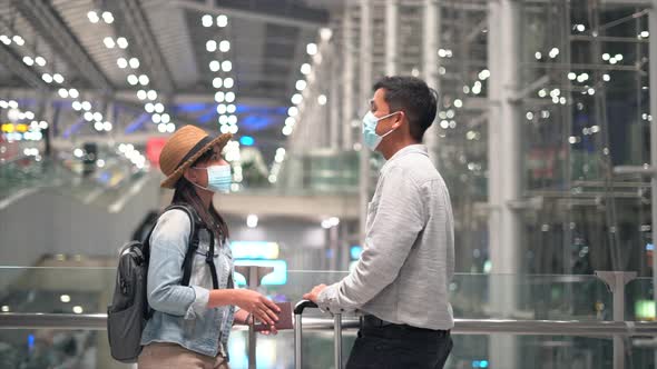 Couple Asian people in airport terminal waiting for flight boarding