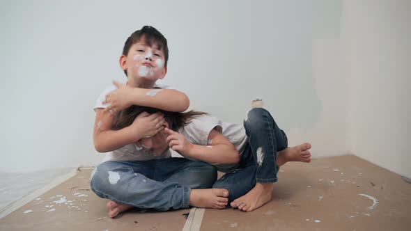 Caucasian Kids Paint the Walls Boy and Girl Took a Break and Have Fun Children's Faces are Painted alt