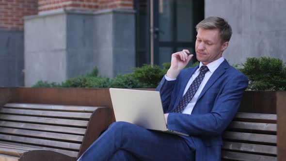 Pensive Businessman Thinking and Working on Laptop alt