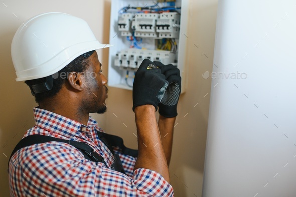 African american electrician Repairing electricity switchboard