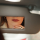 Woman lips in vanity mirror while sitting in car. - PhotoDune Item for Sale