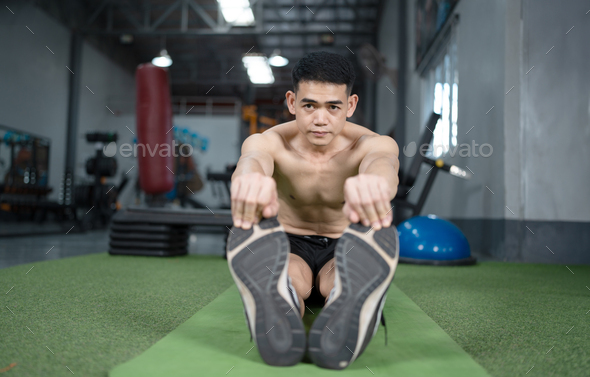 young man reaching hand to foot for hamstring muscle stretch