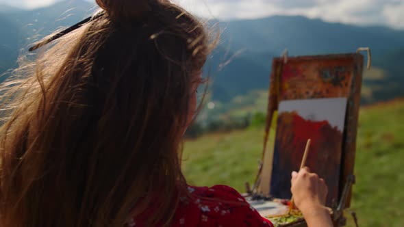 Back View Woman Painter Drawing on Easel Beautiful Mountains Landscape Close Up alt