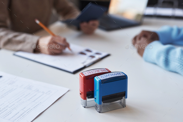 Focus on two stamps with reject and approve status standing on desk