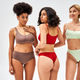 Smiling blonde woman in modern lingerie standing next to multicultural  friends in bras and panties Stock Photo by LightFieldStudios