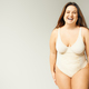 portrait of happy and curvy woman with plus size body posing in beige  bodysuit while laughing on Stock Photo by LightFieldStudios