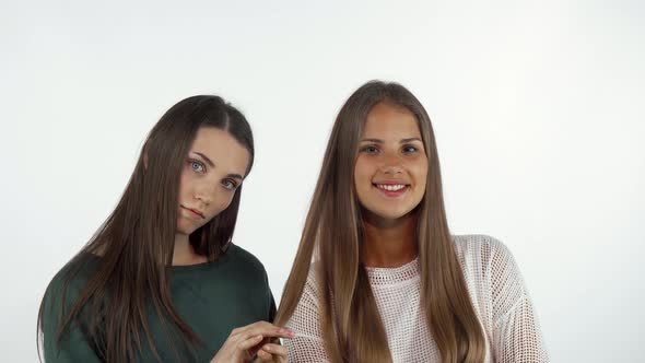 Young Woman Stroking Long Healthy Hair of Her Best Friend alt