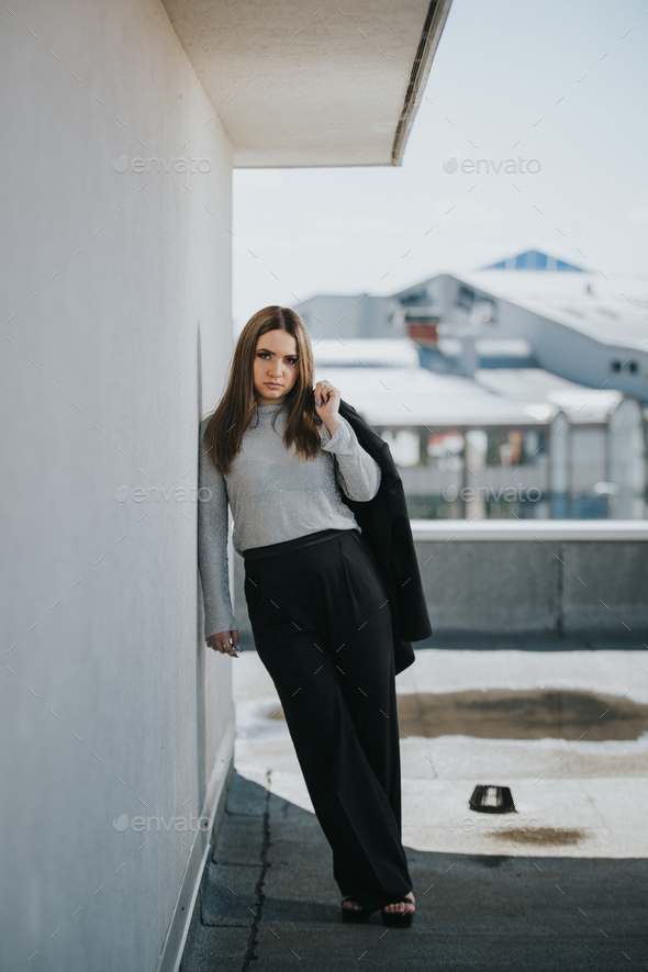 Elegant female from Bosnia and Herzegovina posing on the roof, leaning ...