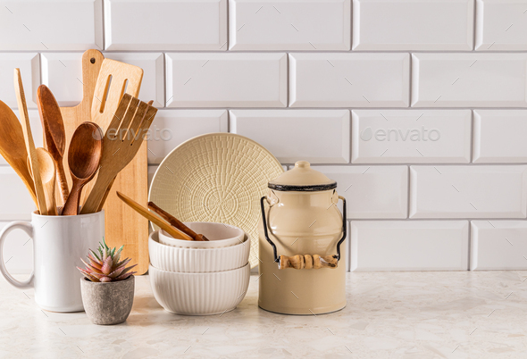 White ceramic utensils and kitchen utensils on a wooden countertop