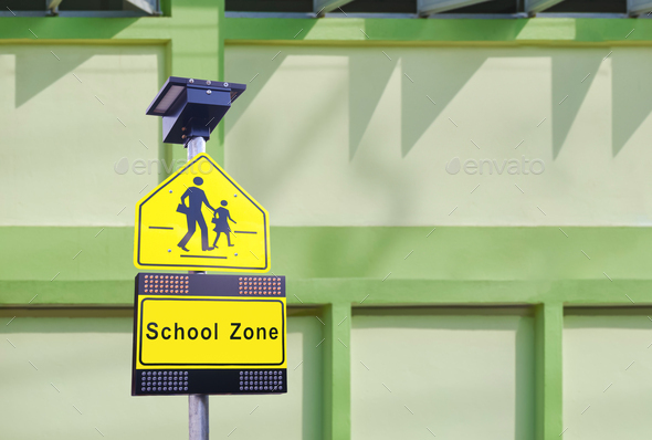 LED solar cell warning light with traffic security school sign on signpost in front of school