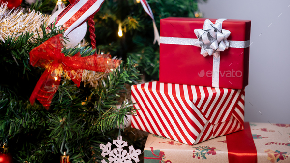 Neatly wrapped gift boxes beneath the contemporary Christmas tree in ...