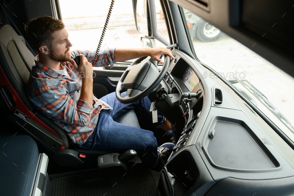 Male truck driver talking by CB radio system in his vehicle
