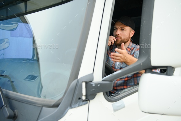 Male truck driver talking by CB radio system in his vehicle