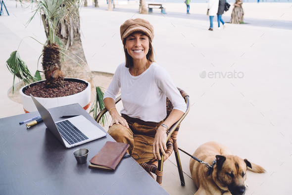 smiling woman looking at camera share content in social media doing freelance job with pet