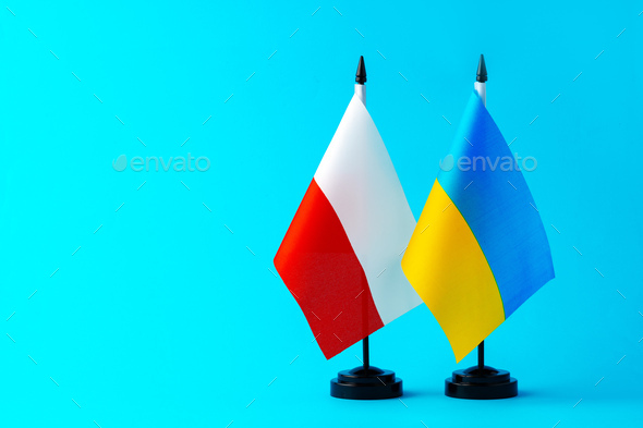 Flags of Ukraine and Poland on blue background