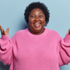 Indoor shot of chubby dark skinned woman keeps palms raised up exclaims loudly shows white teeth - PhotoDune Item for Sale