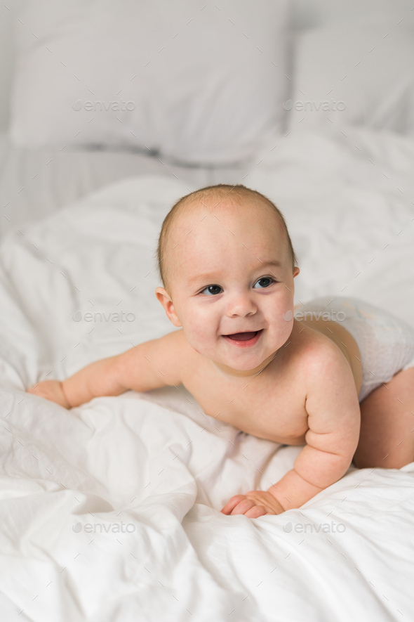  Happy baby lying on bed laughing. Generation alpha and gen alpha Stock ...