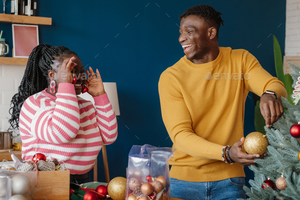 Beautiful Young African Couple Having Fun While Decorating Christmas