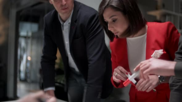 Colleagues And Clients Talking Strategy With Project Blueprint. In Creative Office Productive alt