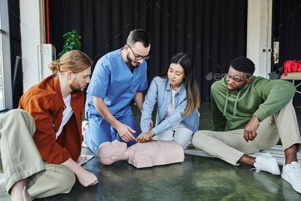 young asian woman practicing life-saving skills by doing chest compressions on CPR manikin near