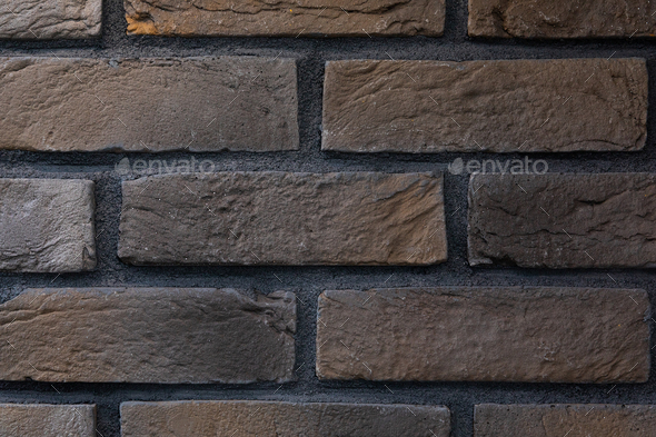 close-up of a facade panel of a brickwork of dark brown and graphite ...