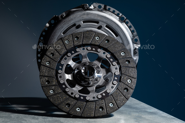Close-up picture of a part of car, black clutch disk isolated on black background