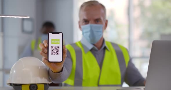 Mature Foreman in Safety Mask Showing Vaccinate Qrcode on Cellphone at Camera alt