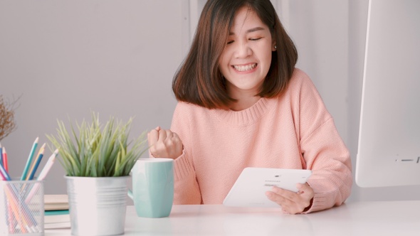 Young Asian woman successful businesswoman using a tablet at the home office.