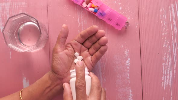 Top View of Senior Women Taking Pills From Container  alt