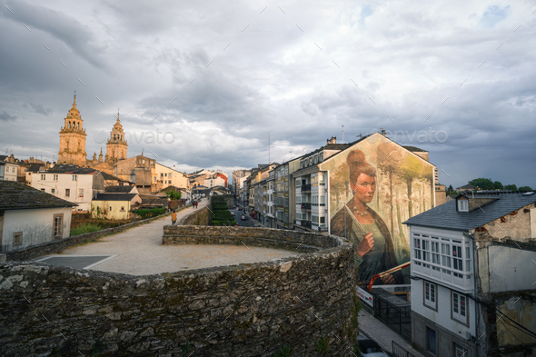 The mural of the ancient Celtic warrior Copora by Yoe33 next to the Roman wall in Lugo
