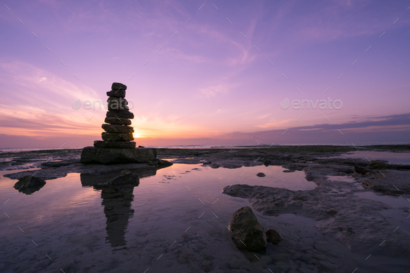 Big rocks stacked in balance on the coast at sunset
