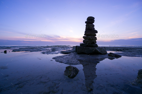 Big rocks stacked in balance on the coast at sunset