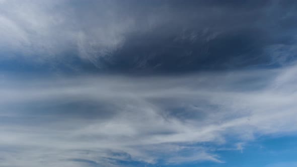 Different types of clouds drifting at the same time on the blue sky. alt