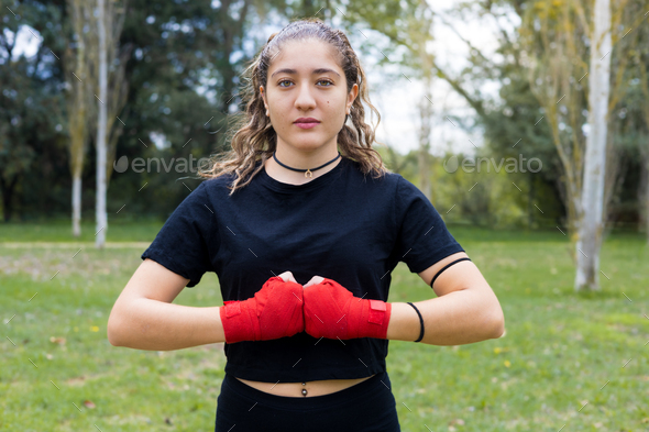 Boxer woman with hands red bandage wrap for boxing outdoors