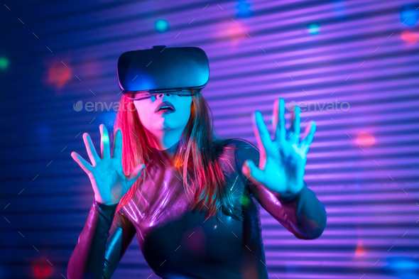 Shocked woman during an interactive game with VR goggles