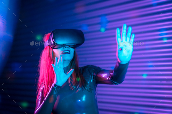 Happy woman during an interactive game with VR goggles