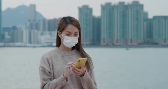 Woman wear face mask and use of mobile phone