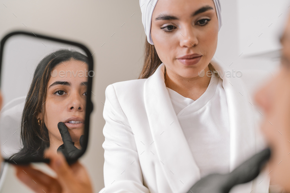 Doctor Using A Mirror Explaining A Facial Aesthetics Surgery Treatment