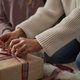 Hands of unrecognizable girl and mother wrapping Christmas gifts on the floor - PhotoDune Item for Sale