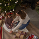 High angle view of caucasian girl and mother wrapping Christmas gifts on the floor - PhotoDune Item for Sale