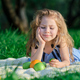 Happy little girl having fun at the park. Cute child sitting on the grass on a sunny summer day. - PhotoDune Item for Sale