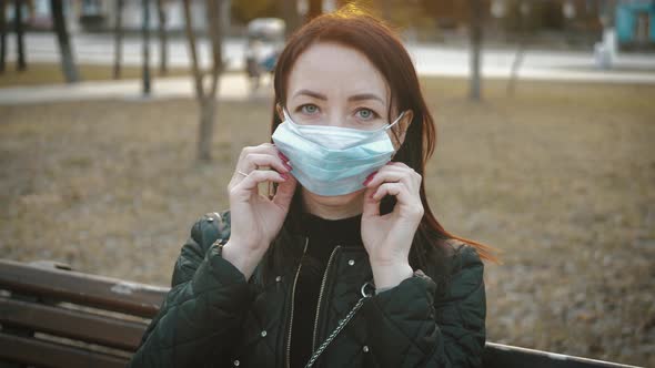 Young Woman in a Medical Mask for Protection From the Epidemic on the Street in the City. Concept alt