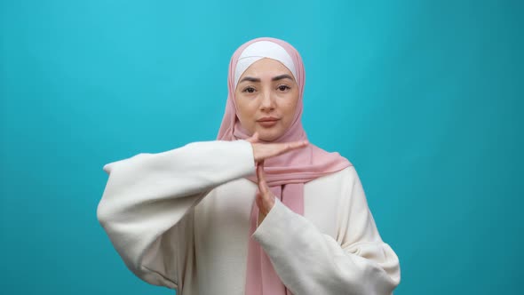 Tired Young Muslim Woman in Hijab Looking with Pleading Frightened Eyes and Showing Time Out Hands