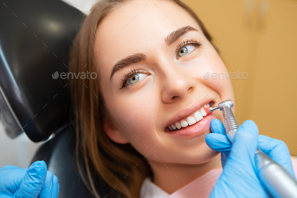 Woman patient sitting in medical chair during teeth grinding procedure