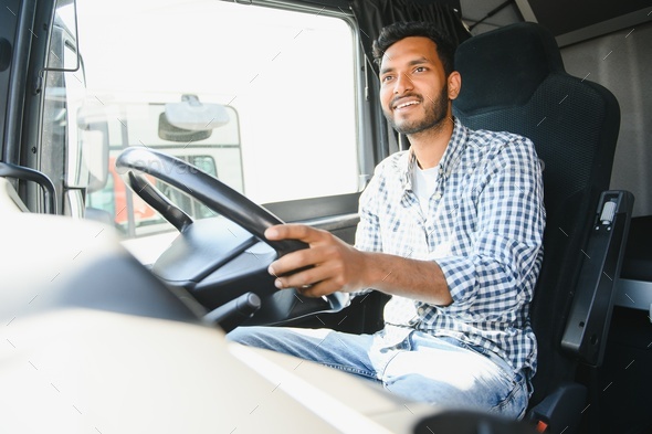 Happy professional truck driver driving his truck. Copy space. Stock Photo  by sedrik2007